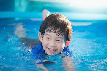 Boy swimming and playing in a pool