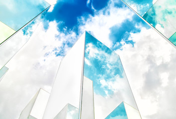 Bottom view of reflection of blue sky on building mirror. Abstract background.