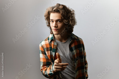 Isolated Shot Of Charming Guy With Voluminous Wavy Hair Having