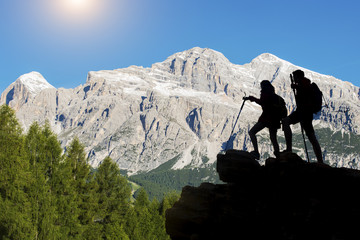 Hiker with backpacks reaches the summit of mountain peak. Success, freedom and happiness, Achievement in mountains. Active sport concept.