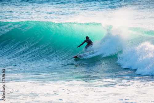 Surfer on blue wave. Winter surfing in ocean