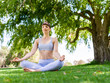 © Sergey Nivens - Young woman practicing yoga in the park