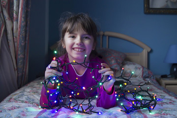 little girl with christmas lights
