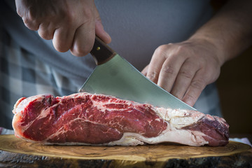 Carnicero cortando carne de entrecot de ternera para la comida