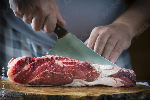 Fotografie, Obraz Carnicero cortando carne de entrecot de ternera para la comida