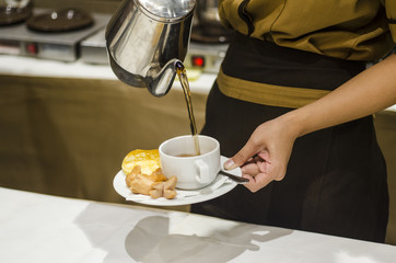 Blurred for Background.The waitress filed a glass of white coffee with the sausage between the brake and the brake food background.