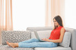 © Africa Studio - Beautiful young woman with modern laptop on sofa at home