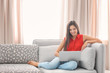 © Africa Studio - Beautiful young woman with modern laptop on sofa at home