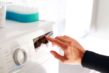 man choosing program for washing machine