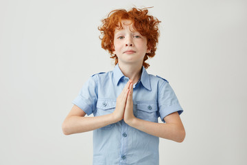 Wall Mural - Funny beautiful boy with ginger hair and freckles pleasing literature teacher to write hard test next week with unhappy face expression.