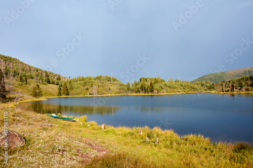 Plakat Spokojny wiejski jezioro z kajakiem na linii brzegowej