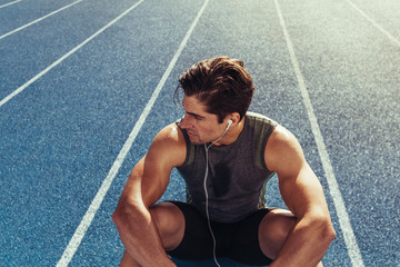Wall Mural - sprinter relaxing on running track