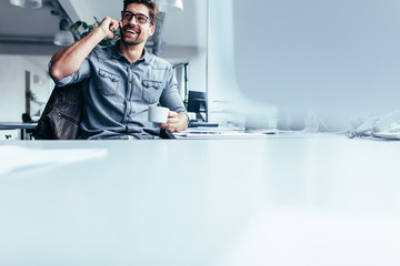 Male executive answering to call at his desk