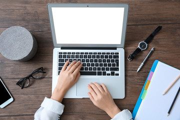 Wall Mural - Young woman using laptop with blank screen at table