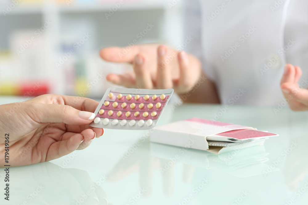 Girl buying contraceptive pills in a pharmacy - obrazy, fototapety, plakaty 