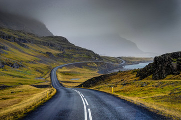 empty street with icelandic landscape during with misty mountain