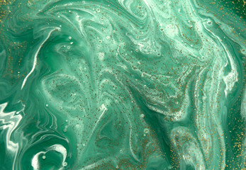  Marbled green abstract background with golden sequins. Liquid marble ink pattern.