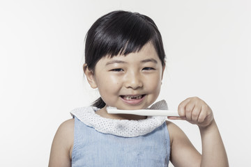 Wall Mural - Pretty asian girl hand holding a white tooth brush with smile isolated white.