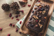 Fresh homemade mixed nut chocolate dried fruit cake on a wooden plate