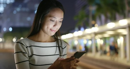 Wall Mural - Young woman use of smart phone at night