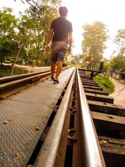 A man walking on the rail way. 