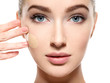 © Valua Vitaly - Young woman with cosmetic foundation on skin.