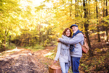 Senior Couple On A Walk In Autumn Forest.