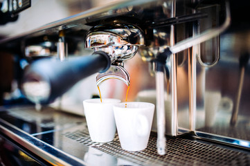 Wall Mural - Automatic espresso machine pouring fresh brewed coffee into cups