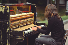 Street Musician Playing The Old Shabby Piano