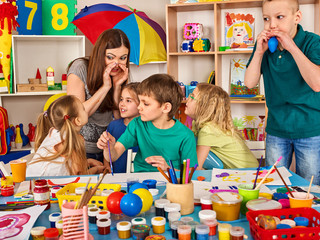 Wall Mural - Small students with teacher finger painting in art school class. Development of creative potential in children. Mom and kids at home. Craft drawing education develops creative abilities of children.