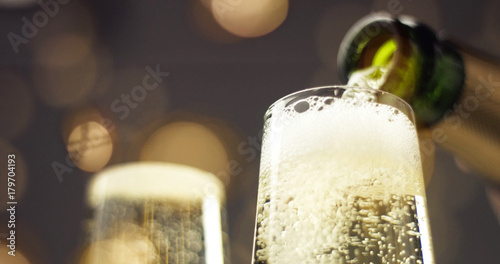 Fotomural Bottle of sparkling wine with three flute glasses with bubbles floating up on gr