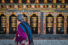 Old Woman Spinning Prayer Wheels In Thimphu, Bhutan