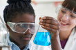© highwaystarz - Female Pupil And Teacher Conducting Chemistry Experiment