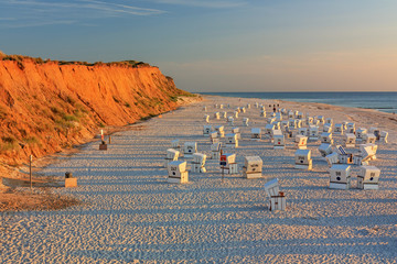 Strand mit Strandkörben am Roten Kliff bei Kampen auf Sylt an der Nordsee bei Sonnenuntergang