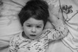 © alexkich - Black and white photo portrait of a young child lying on a pillo