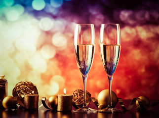 two champagne glasses against holiday lights and fireworks - new year celebration