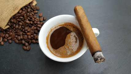 Coffee cup, beans and cigar  on dark  background