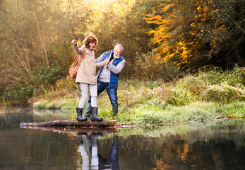 Senior couple on a walk in autumn nature.