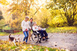 © Halfpoint - Extended family with dog on a walk in autumn nature.