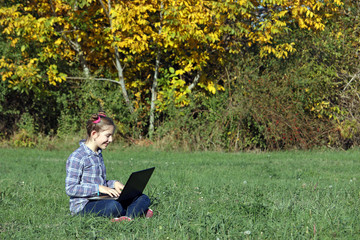 Wall Mural - happy little girl playing laptop