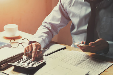 Fototapete - businessman working on desk office with using a calculator and telephone, finance accounting concept