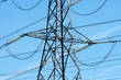 High voltage cables on pylon against a blue summer sky.