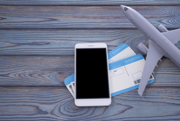 mock up screen of the mobile phone stores air tickets. Modern technology, applications for smartphones, online flat concepts. on a wooden background