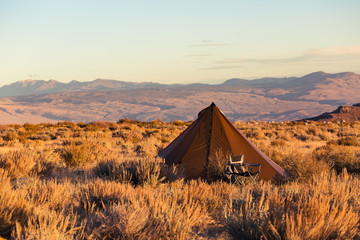 Wall Mural - Indian style tipi tent with folding camp chair nearby pitched in the desert under the mountains of the Sierra Nevada