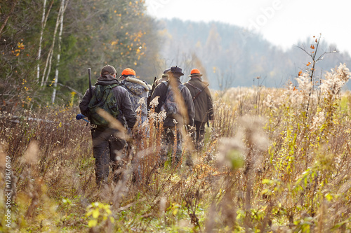 Photographie group of hunters during hunting in forest, chase hunting