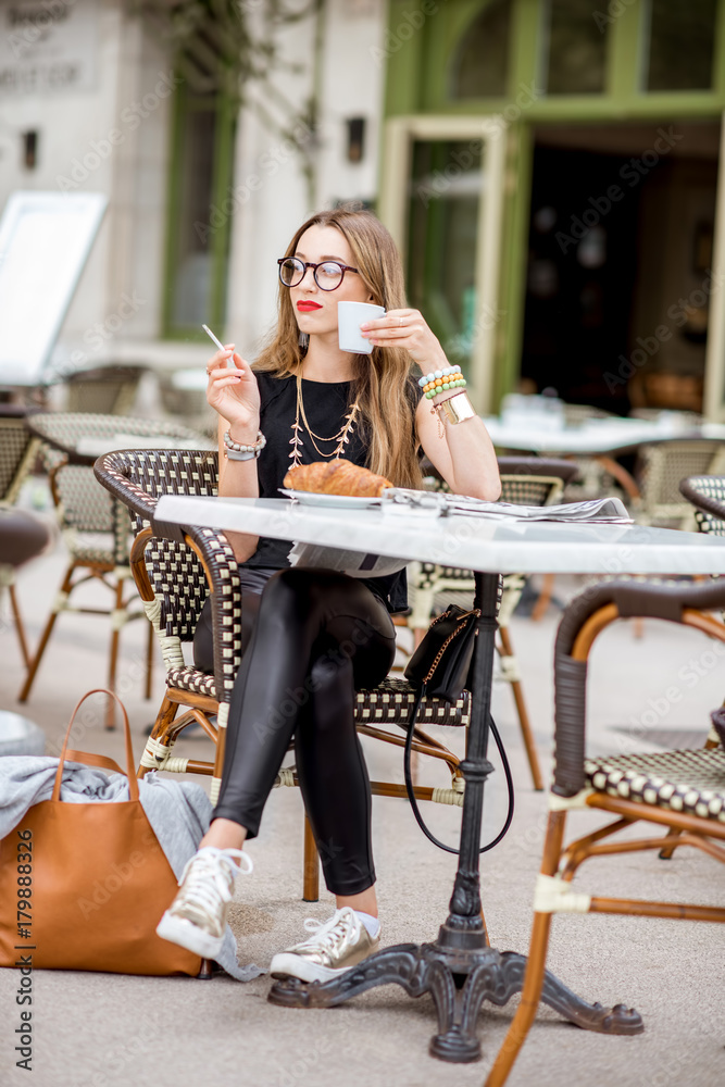 french breakfast cigarette coffee Young woman smoking a cigarette while having a breakfast outdoors at the  typical french cafe terrace in France Stock Photo
