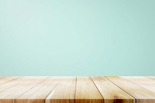 empty wooden deck table over mint wallpaper background.