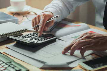 Fototapete - accountant working on desk office with using a calculator finance accounting concept
