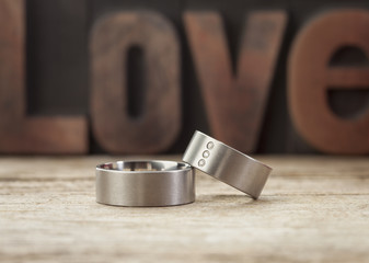 Wall Mural - platinum wedding rings in front of word love