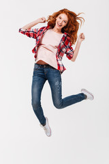 Canvas Print - Happy young redhead lady jumping isolated